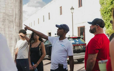 Tour guide leading a group in Santo Domingo, pointing at a historic building.