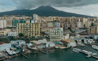 Naples cityscape with Mount Vesuvius in the background, part of a self-guided walking tour.