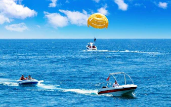 Parasailing over the Red Sea with boats in Sharm El Sheikh.