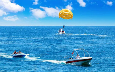 Parasailing over the Red Sea with boats in Sharm El Sheikh.