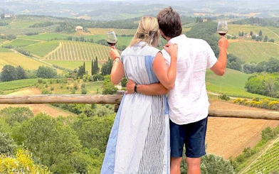 Couple enjoying wine overlooking vineyards in Tuscany during a small-group tour.
