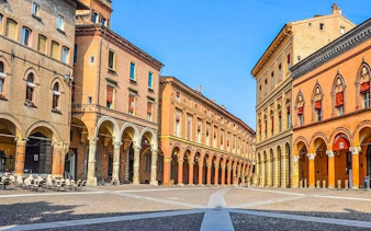 Bologna's historic porticoed buildings on a sunny day, part of a self-guided walking tour.