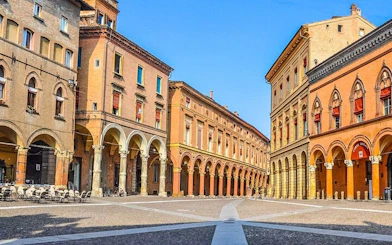 Bologna's historic porticoed buildings on a sunny day, part of a self-guided walking tour.