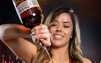 Bartender pouring whiskey during Downtown Las Vegas bar crawl experience.