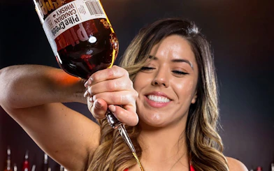 Bartender pouring whiskey during Downtown Las Vegas bar crawl experience.