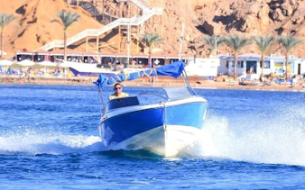 Private speedboat cruising along Sharm El Sheikh coast with scenic backdrop.