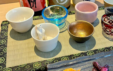 Sake cups and bottles arranged for a tasting session in Kyoto.