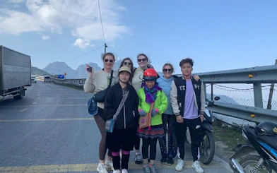 Group of tourists on a Sapa motorbike tour with scenic mountain view in the background.