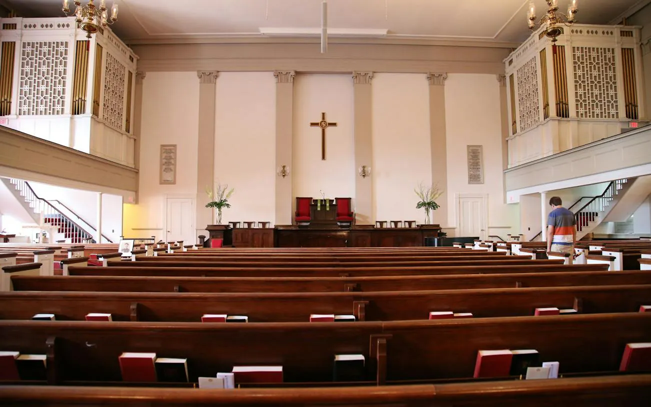 Interior of a historic church along the Boston Freedom Trail, featuring wooden pews and a central cross.
