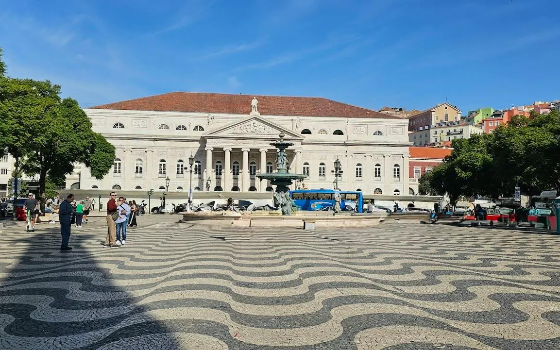 Rossio Square with wave-patterned pavement and fountain, Lisbon Baixa and Chiado walking tour.