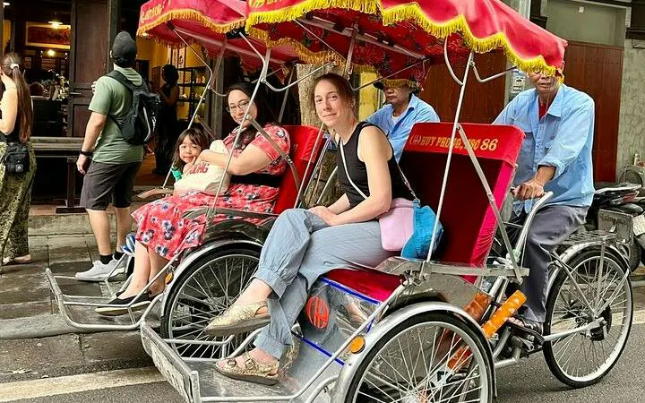 Cyclo ride through Hanoi's Old Quarter with passengers enjoying the street view.