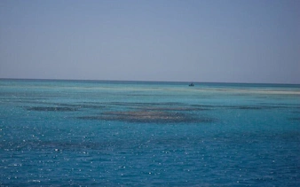 Clear blue waters of 3 Pools National Park, Dahab, with distant boat.