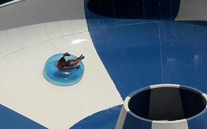 Person on a tube sliding down a funnel ride at Splash Jungle Water Park, Phuket.