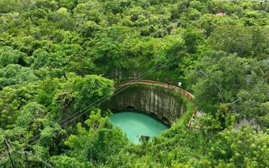 Punta Cana blue lagoon cenote surrounded by lush greenery, part of off-road buggy adventure.