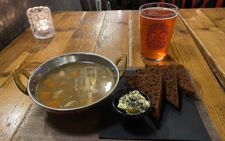 Icelandic lamb soup with rye bread and butter on a wooden table, Reykjavik tour tasting.