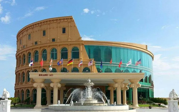 Colosseum Show Pattaya building with fountain and international flags, Pattaya.