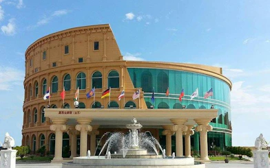 Colosseum Show Pattaya building with fountain and international flags, Pattaya.