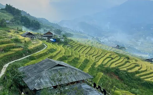 Terraced rice fields and traditional houses in Ta Van village, Sapa, Vietnam.