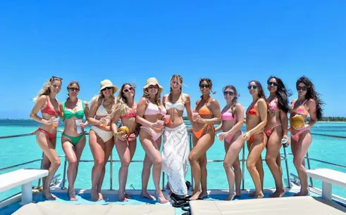 Group enjoying catamaran party cruise in Punta Cana with open bar and ocean view.
