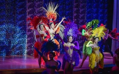 Cabaret performers in colorful costumes on stage at Golden Dome, Bangkok.