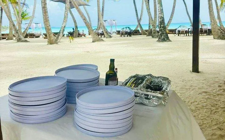 Beachside setup with plates and drinks for Saona Island day trip lunch, Punta Cana.