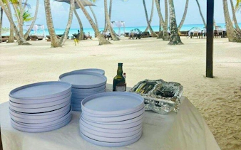 Beachside setup with plates and drinks for Saona Island day trip lunch, Punta Cana.