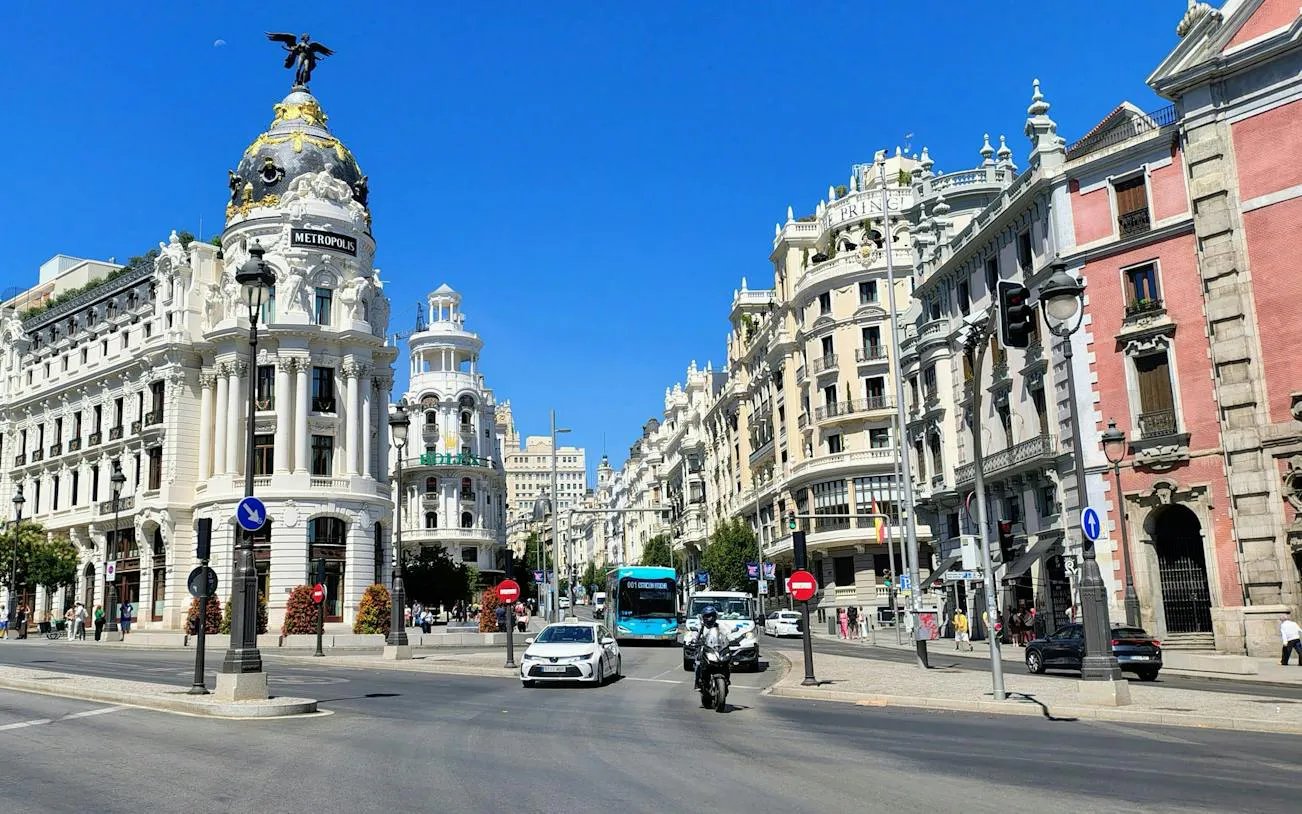 Metrópolis Building on Gran Vía, Madrid, with traffic and pedestrians.