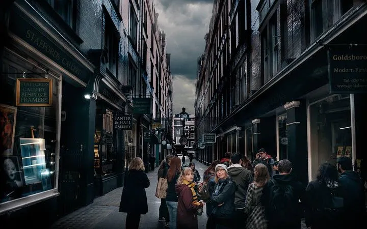 Walking tour group exploring Harry Potter filming locations in a narrow London alley.