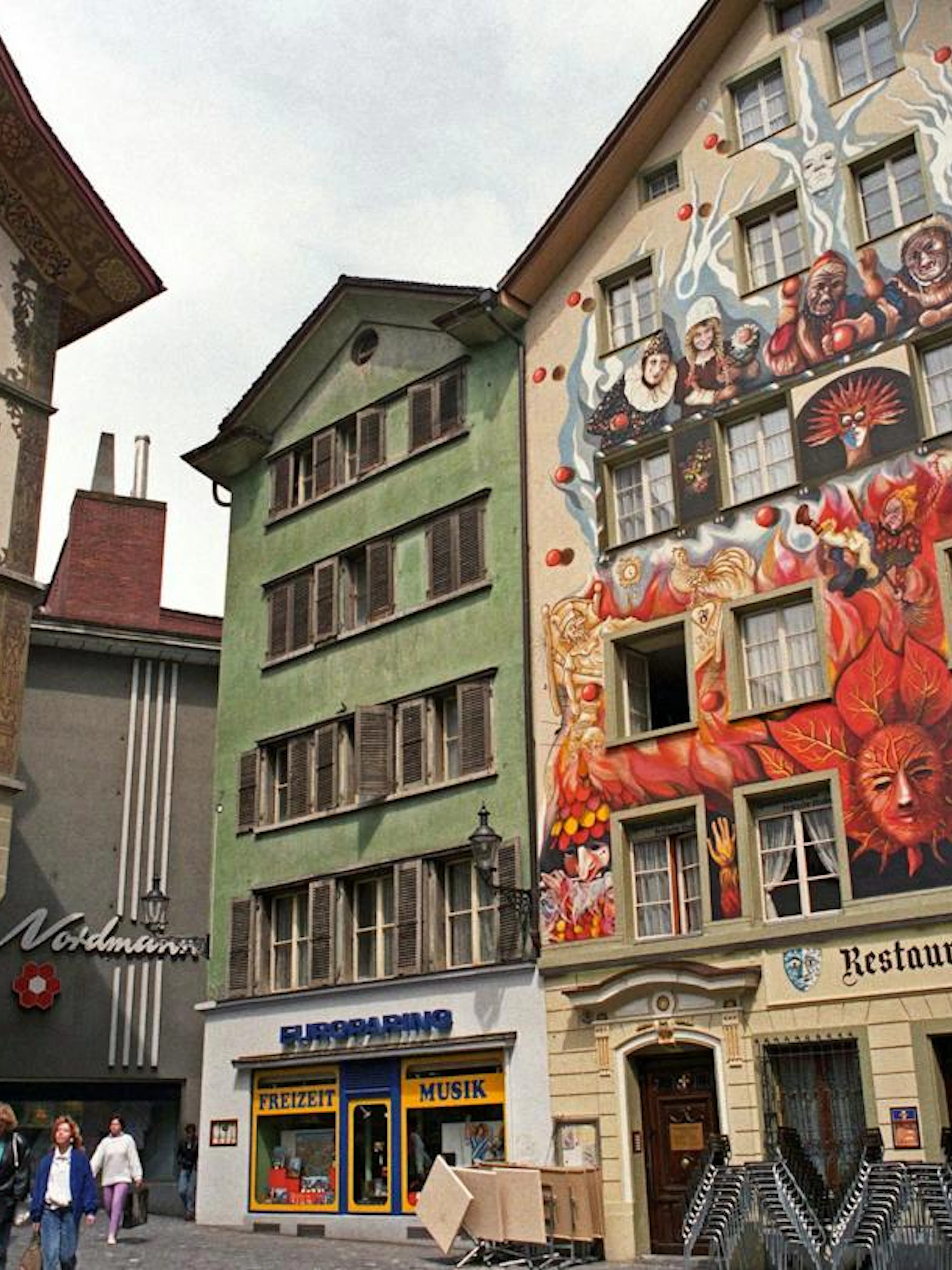 Colorful murals on historic buildings in Lucerne Old Town during a self-guided audio walking tour.