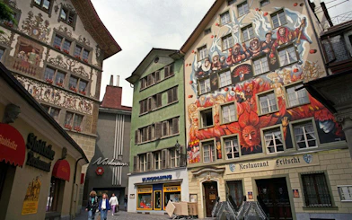 Colorful murals on historic buildings in Lucerne Old Town during a self-guided audio walking tour.