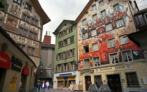 Colorful murals on historic buildings in Lucerne Old Town during a self-guided audio walking tour.