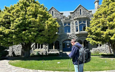 Christchurch small group tour visitor outside historic stone building.