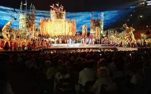 Opera performance at Arena di Verona with elaborate stage set and audience.