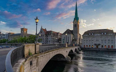 Zurich Old Town bridge with Fraumünster Church at sunset, part of guided tour.