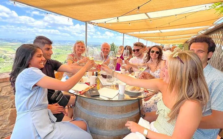 Group enjoying wine tasting in Tuscany with scenic views during a day trip from Rome.