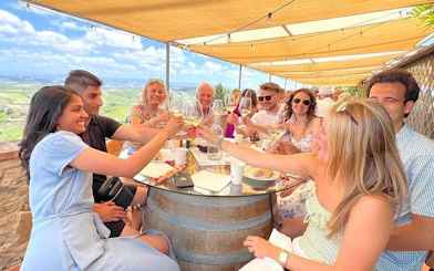 Group enjoying wine tasting in Tuscany with scenic views during a day trip from Rome.