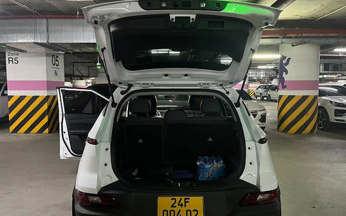 Private car in parking garage for Sapa to Ha Noi transfer with open trunk.