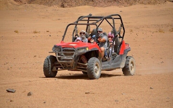 Family riding buggy car on desert safari in Sharm El Sheikh's Echo Valley.