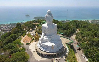 Big Buddha statue overlooking Phuket City with ocean view.