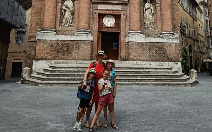 Family exploring historic church facade in Siena during self-guided city game.