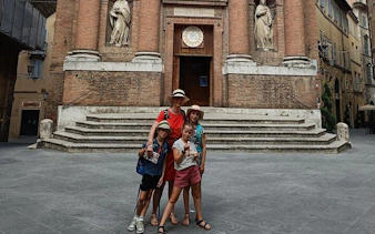 Family exploring historic church facade in Siena during self-guided city game.