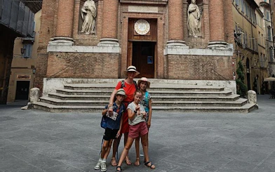 Family exploring historic church facade in Siena during self-guided city game.