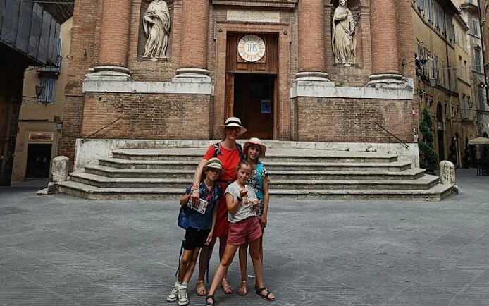 Family exploring historic church facade in Siena during self-guided city game.