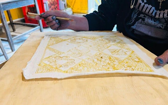 H’Mong artisan creating batik design with beeswax in Sa Pa workshop.