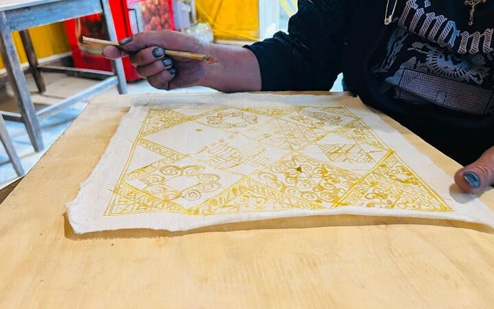 H’Mong artisan creating batik design with beeswax in Sa Pa workshop.
