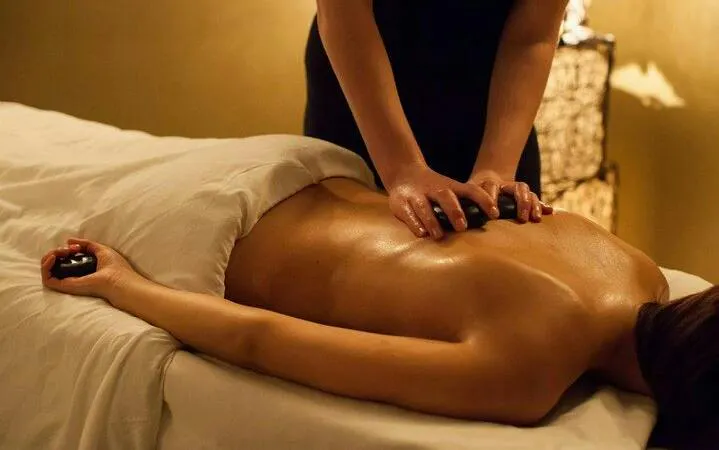 Massage therapy session at Istanbul Turkish Bath with hot stones.