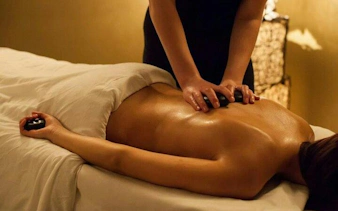 Massage therapy session at Istanbul Turkish Bath with hot stones.
