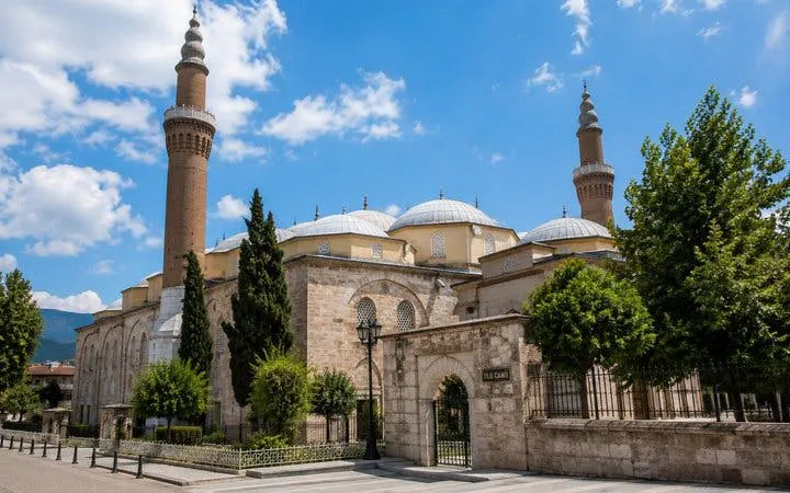 Ulu Mosque in Bursa with its minarets and domes under a clear blue sky.