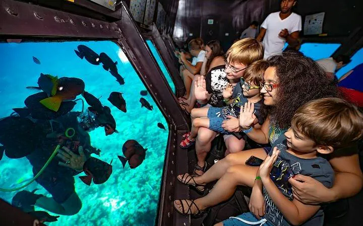 Visitors observing fish through submarine windows on a sea trip in Hurghada.