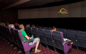 Visitors seated in a theater watching a Culturama presentation in Sharm El Sheikh.
